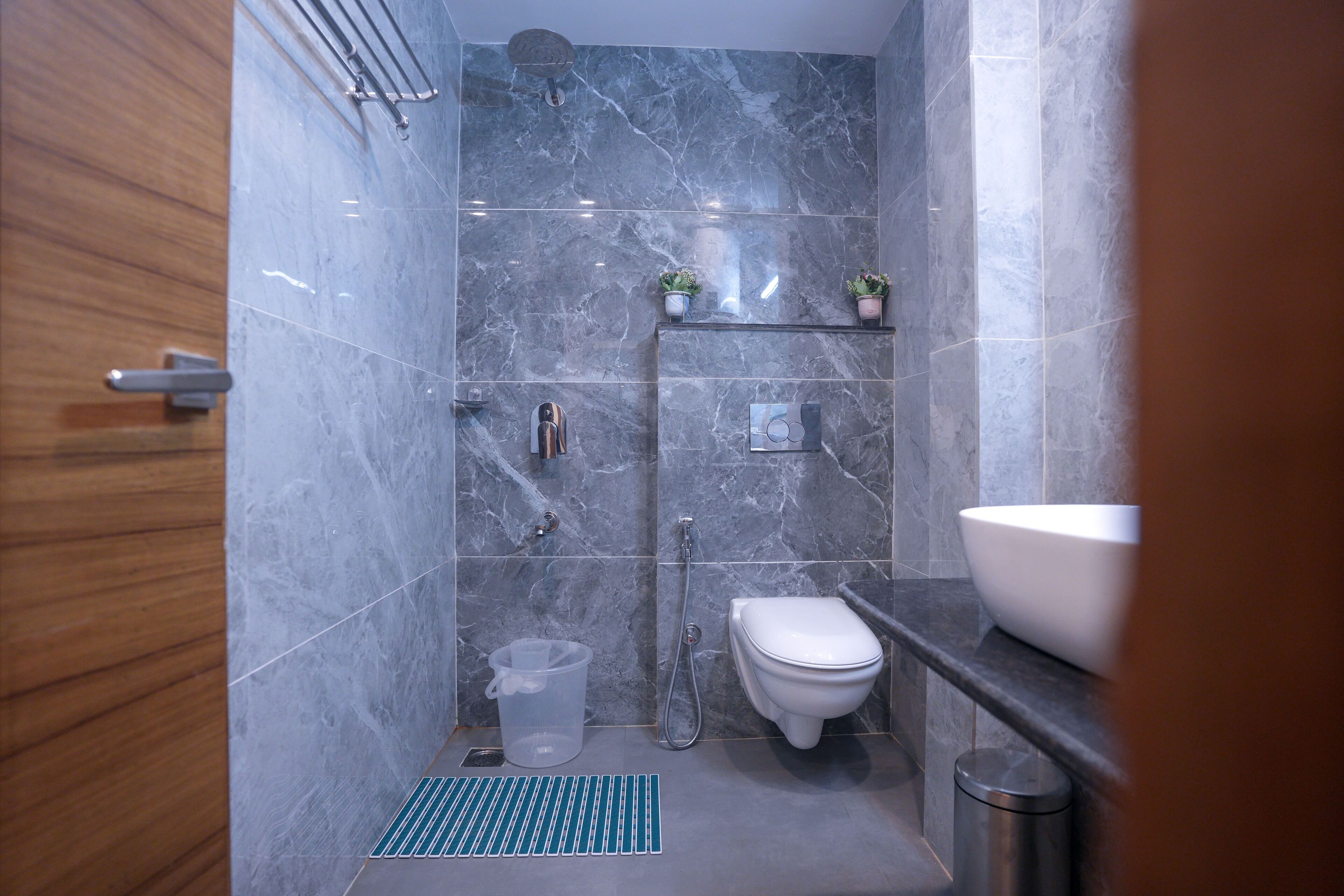 A modern bathroom with a shower, toilet, and sink.