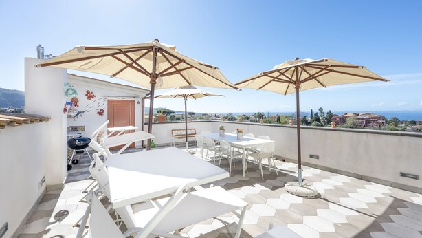 A rooftop terrace with white lounge chairs, beige umbrellas, and a tiled floor. - Villa Fienga - Maison Edvige 8 beds (Meta)