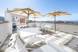 A rooftop terrace with white lounge chairs, beige umbrellas, and a tiled floor. - Villa Fienga - Maison Edvige 8 beds (Meta)