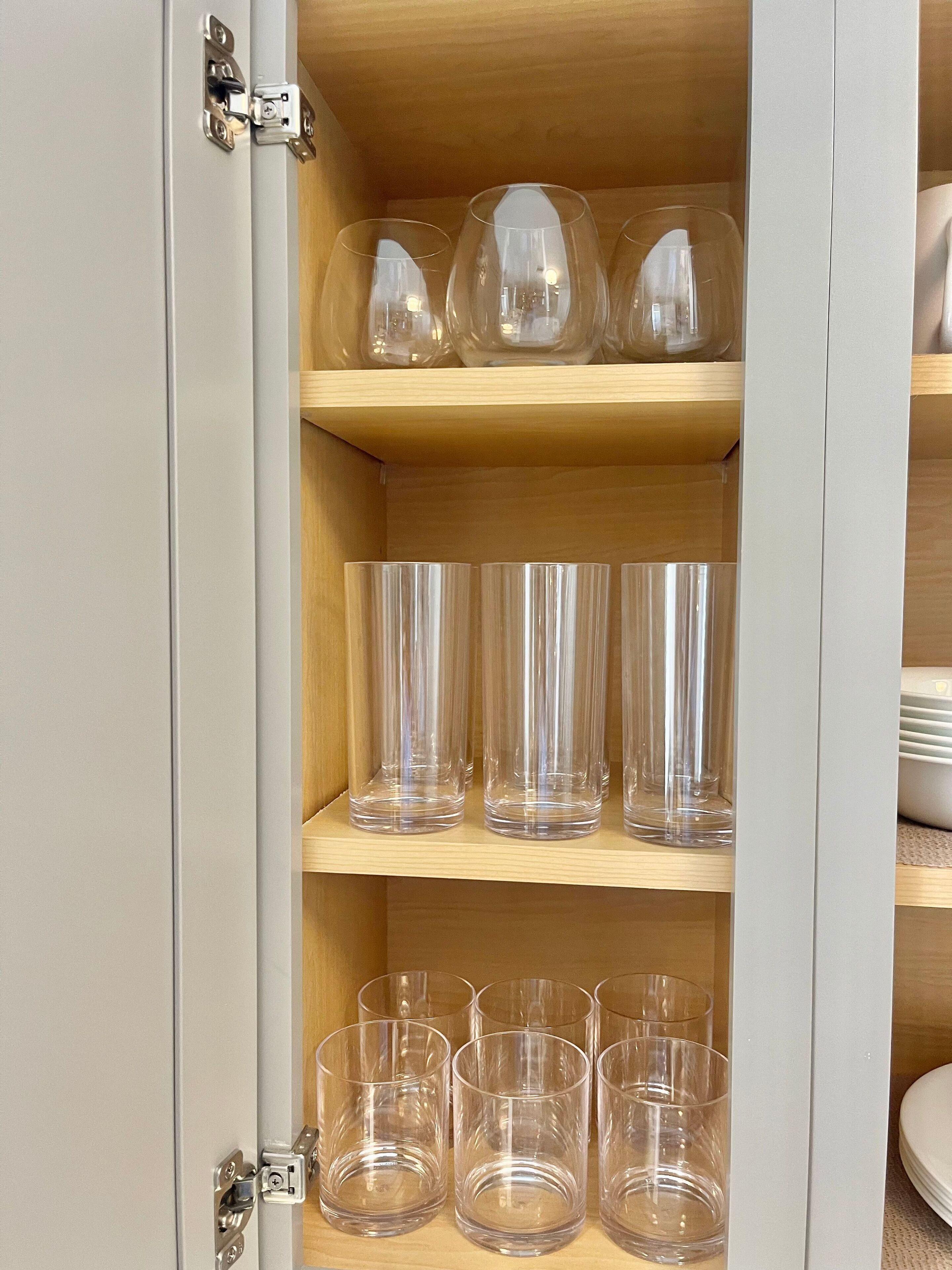 Ein Schrank mit mehreren Einlegeböden, der klares Glasgeschirr beherbergt.