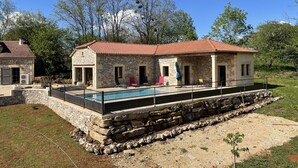 A stone house with a swimming pool, outdoor seating, and a stone retaining wall. - le Gite de Cayla (SAINT-PROJET)