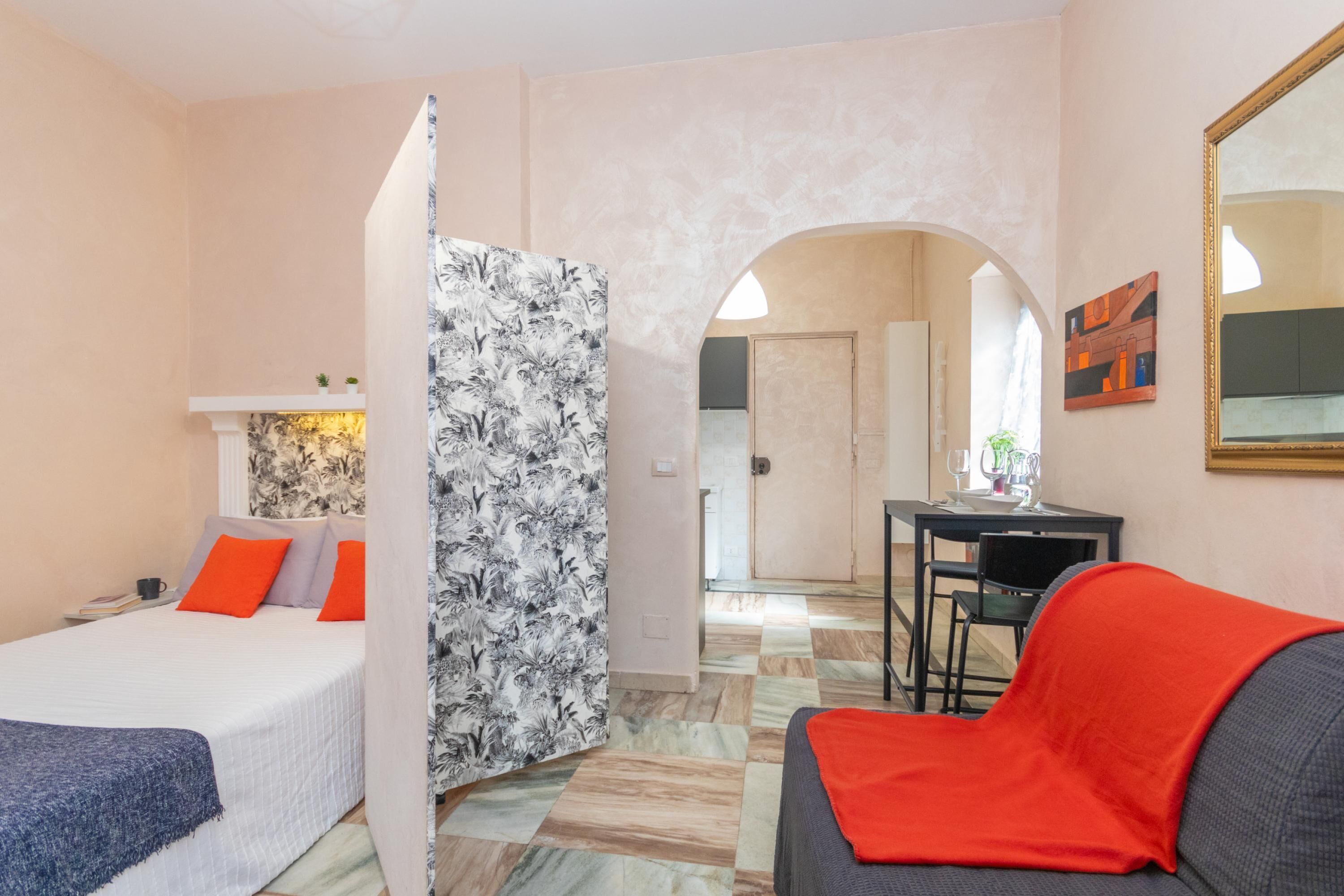 Une chambre d’hôtel comprenant un lit, un canapé, une table à manger et un miroir.