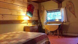 A cozy room with a bed, a desk, and a window. - Hunger Mountain - Grunberg Haus Inn & Cabins (Waterbury)