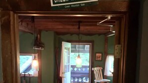 A room with a wooden bench, a hanging light fixture, and a door leading outside. - Green Mountain - Grunberg Haus Inn & Cabins (Waterbury)