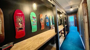 Un couloir où sont exposées des planches de surf et où se trouve un tapis bleu.