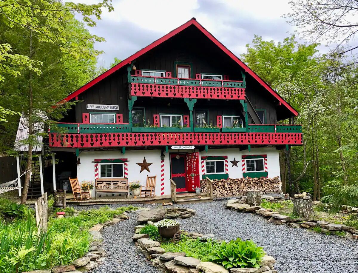 A two-story building with a red roof, green trim, and a welcoming sign.