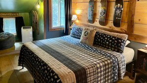 A cozy bedroom with a bed, a window, and a wall-mounted skateboard rack.