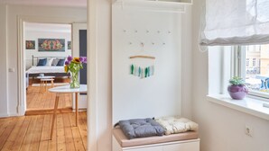 Une chambre à coucher avec un lit, une table de chevet et une fenêtre donnant sur des immeubles.