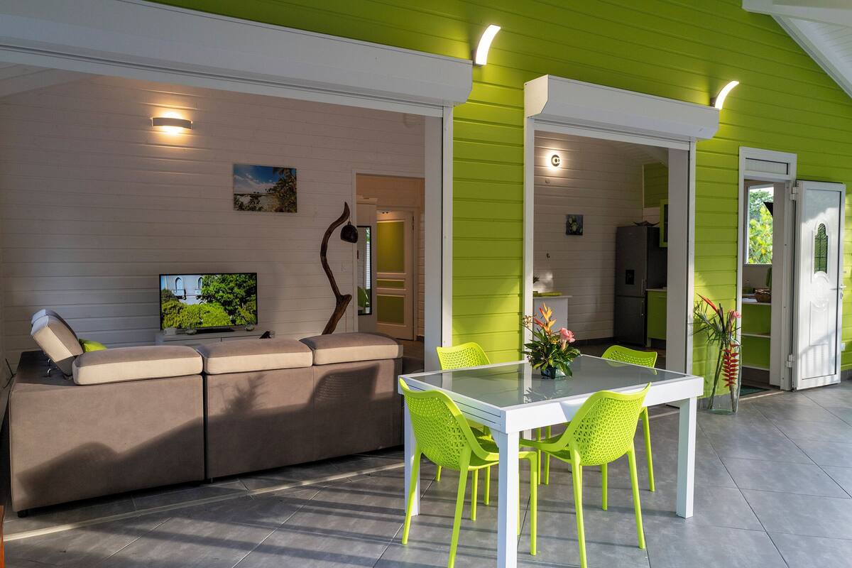 A modern living room with a sofa, TV, and bright green walls.