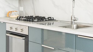 A modern kitchen with a built-in oven, a gas stove, and a stainless steel sink.