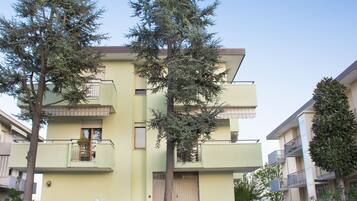 A multi-story building with balconies and a gated entrance.