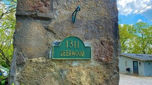 Un mur de pierres sur lequel est fixée une plaque verte indiquant « 1311 Deerwood ».