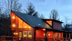 En hytte med store terrasse og trapper op til indgangen.
