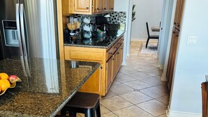 A kitchen with granite countertops, wooden cabinets, and a stainless steel refrigerator. - 5-10 mins to Temecula WineCountry; resort-like pool spa w/ amazing sunset views! (Winchester)