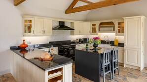 A kitchen with white cabinets, a black countertop, and a central island with bar stools.