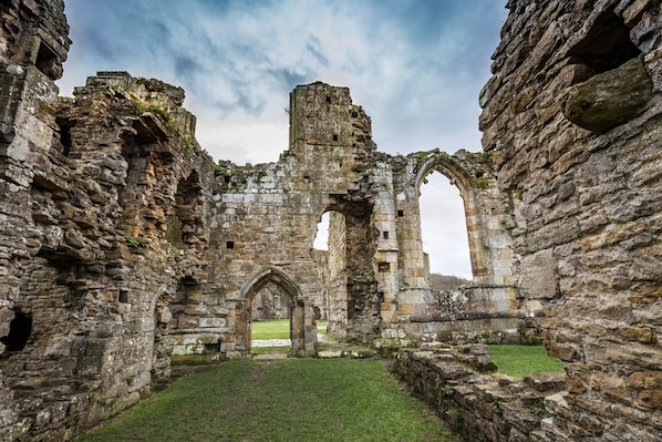 El interior de un edificio histórico de piedra con arcos y ruinas.