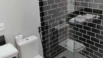 Un baño moderno con inodoro, lavamanos y zona de ducha.