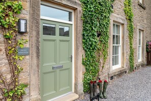 A stone building with a green door, ivy-covered walls, and a sign reading "THE OLD SCHOOL ROOMS". - The Wensleydale -  a cottage that sleeps 2 guests  in 1 bedroom (Richmond)