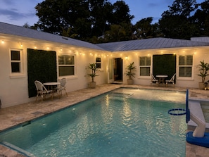 A swimming pool with a basketball hoop, surrounded by outdoor seating and potted plants. - Tropical Oasis with Private Pool & Spa, minutes from Siesta Key Beach! (Sarasota)