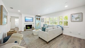 A spacious living room with a fireplace, a large TV, and a comfortable seating area. - Tropical Oasis with Private Pool & Spa, minutes from Siesta Key Beach! (Sarasota)