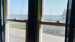 A room with a large window overlooking a road and a building. - Actual Pretty Boy Floyd Hideout  Lake Erie, MI (Luna Pier)