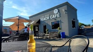 A Luna Pier Beach Café with outdoor seating and a Corona beer bottle on a table. - Actual Pretty Boy Floyd Hideout  Lake Erie, MI (Luna Pier)