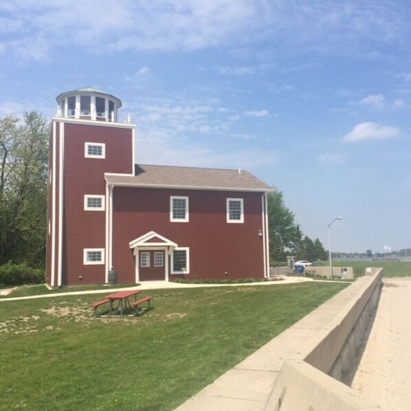 A red brick building with a small tower, a picnic table, and a concrete barrier.