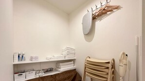 A bathroom with a sink, mirror, towel rack, and a hairdryer. - Nikke 202 (Hiroshima)