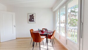 A dining area with a round table, four chairs, and a framed artwork on the wall. - Brasseur (Colmar)