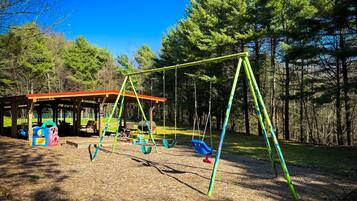 A playground with swings and a covered seating area.