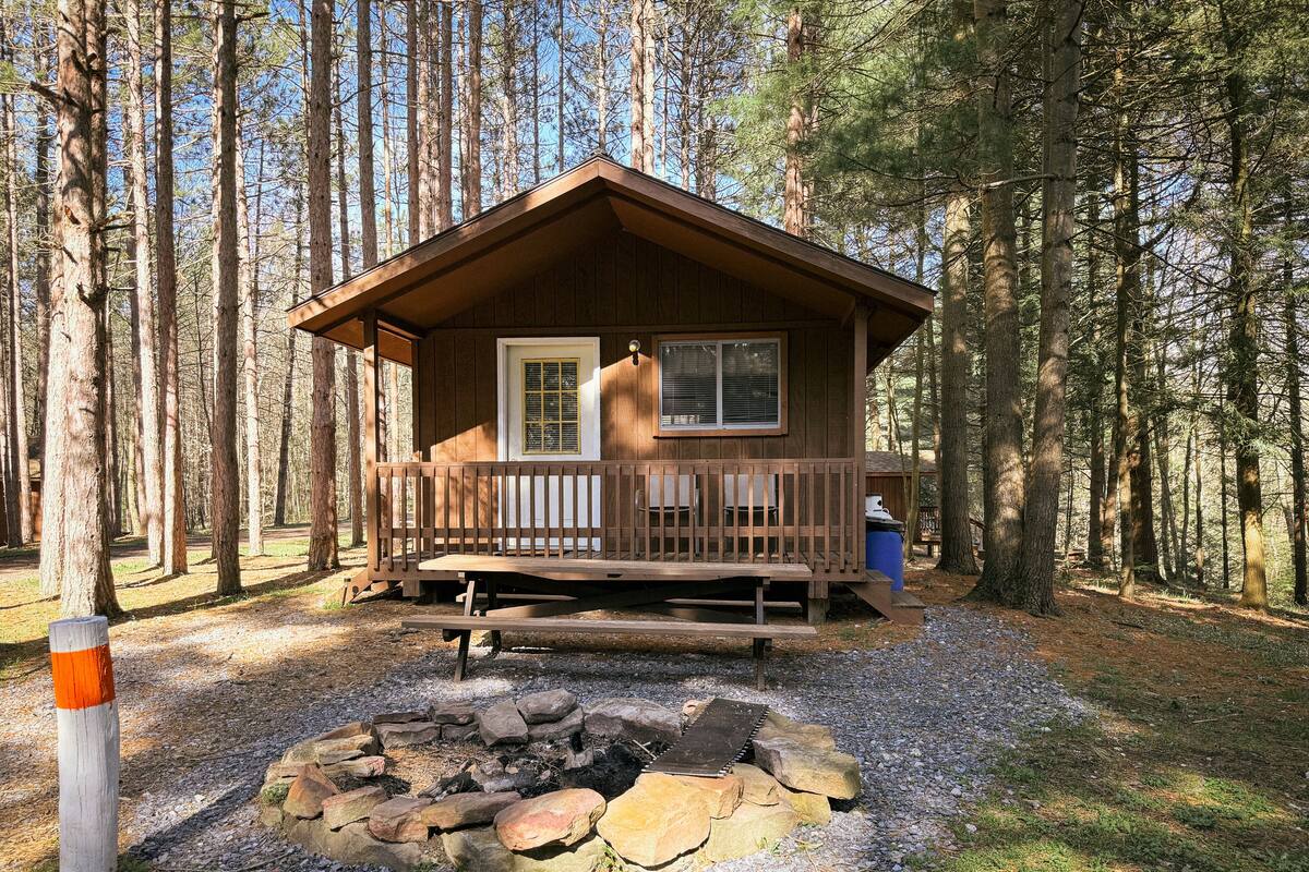 Een vakantiehuis met een veranda, vuurkorf en een houten terras.