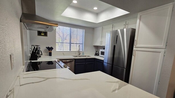 A modern kitchen with a central island, stainless steel appliances, and a skylight. - Tempe 2Bdrm 2Ba by Papago Park A101 (Tempe)