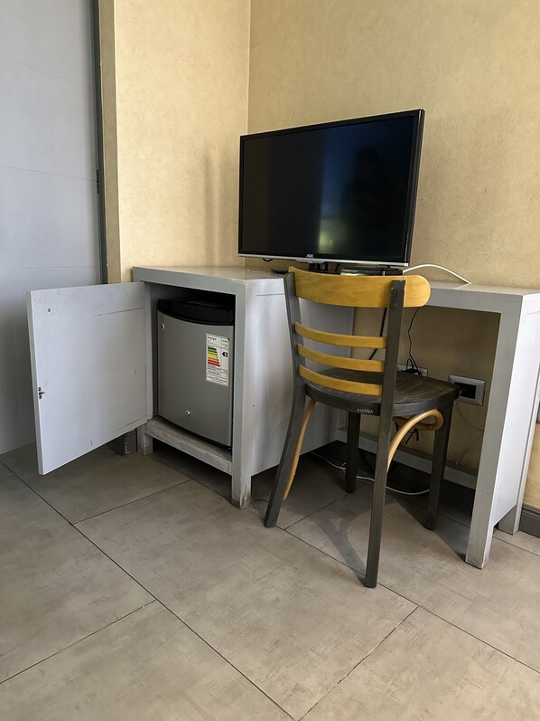 A compact workspace with a desk, chair, and a television.