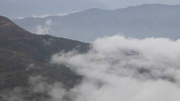 Un paisaje montañoso con un valle y una carretera serpenteando a través de él.