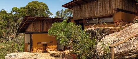 A rustic building with a wooden deck and a stone wall.