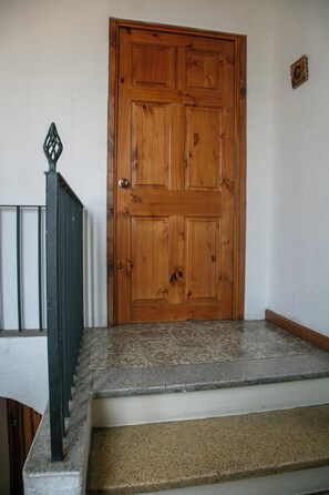 A wooden door with a metal gate to the left.