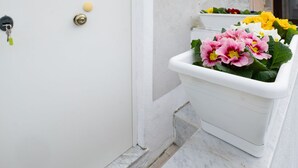 A white door with a keyhole and a small round object on the door handle.
