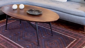 A living room with a gray sofa, a wooden coffee table, and a patterned rug. - Silk Stocking District historical mid-century home (Galveston)