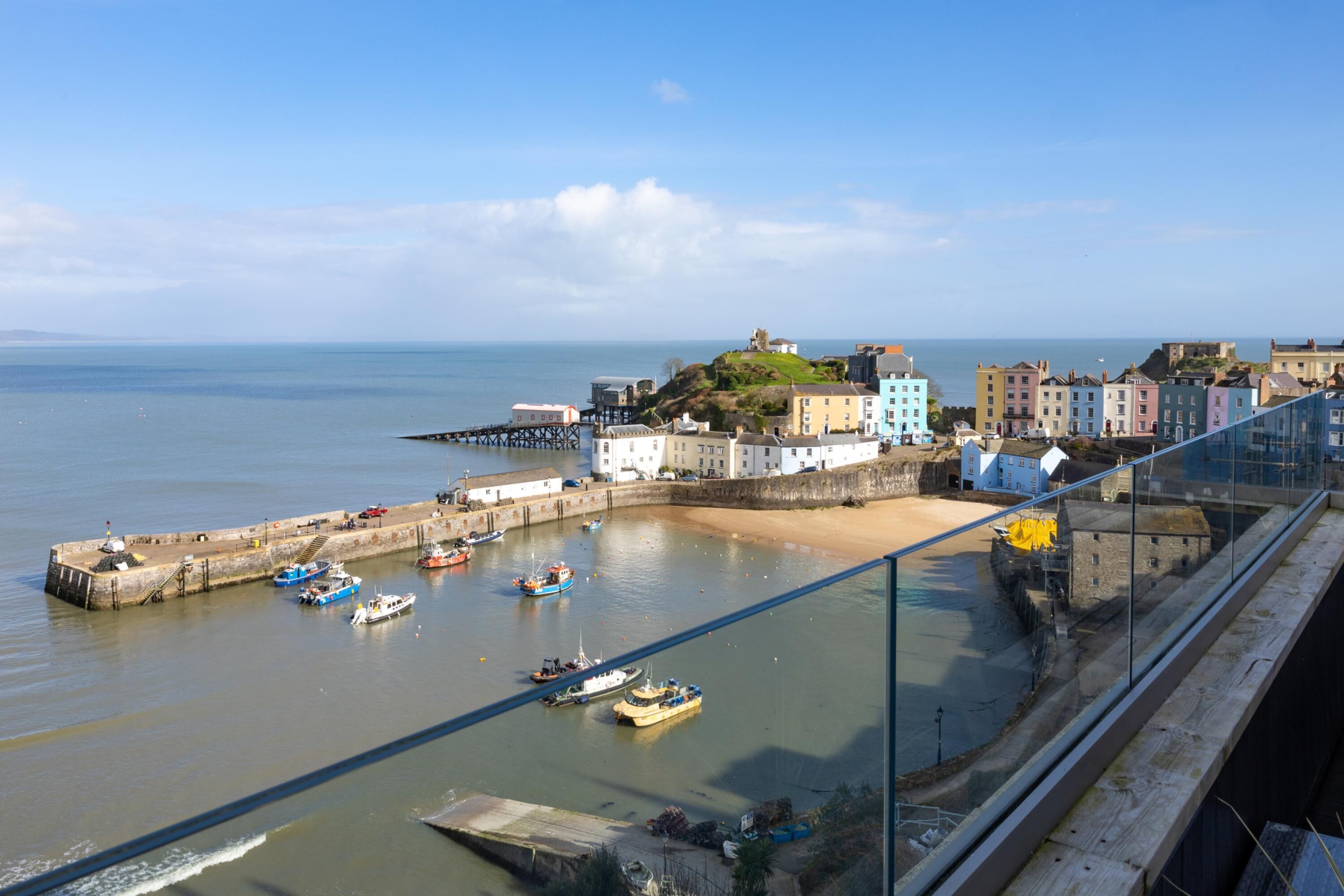 A coastal town with a pier, boats, and historic buildings.