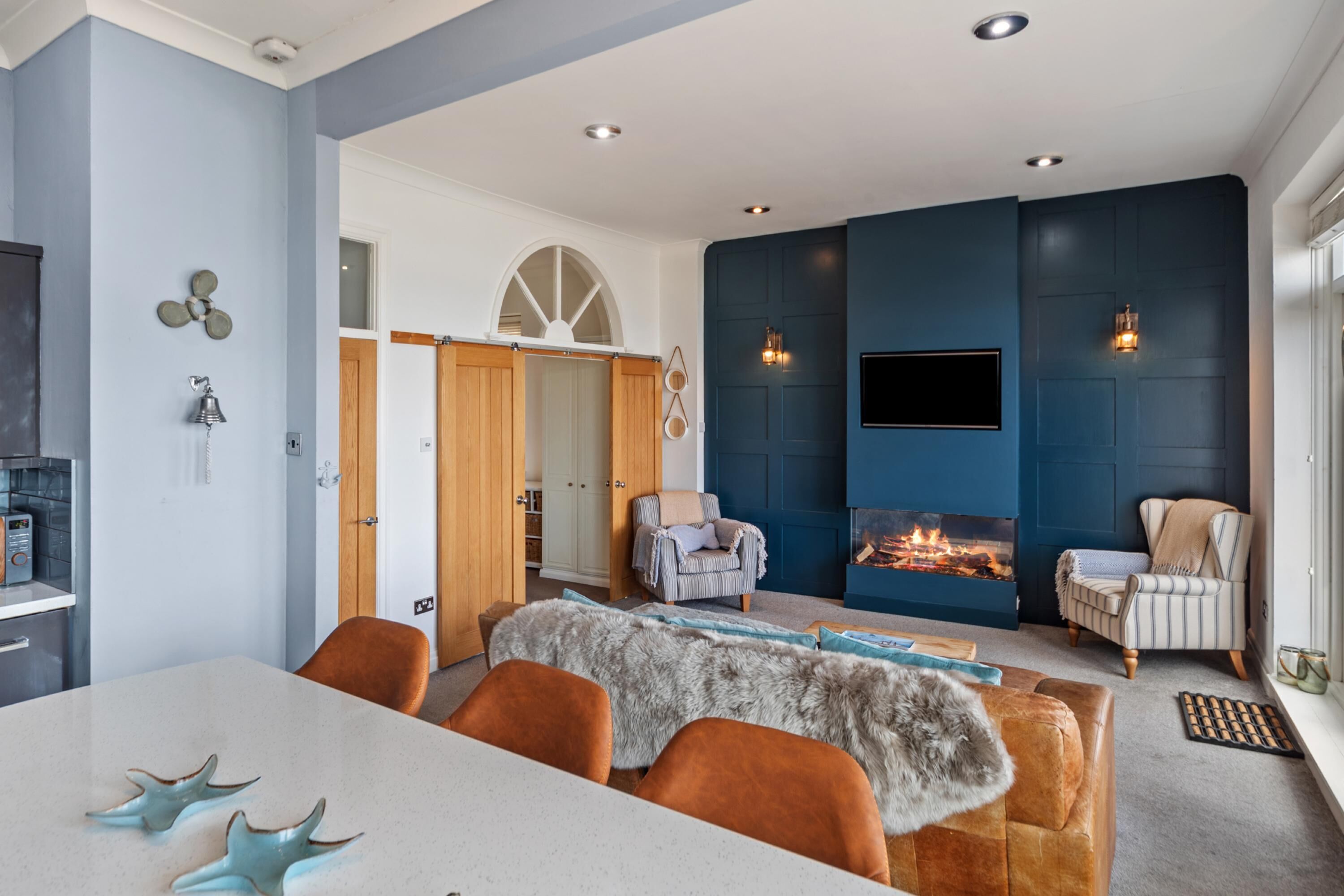 Una sala de estar moderna con chimenea, zona de estar y una mesa de comedor.
