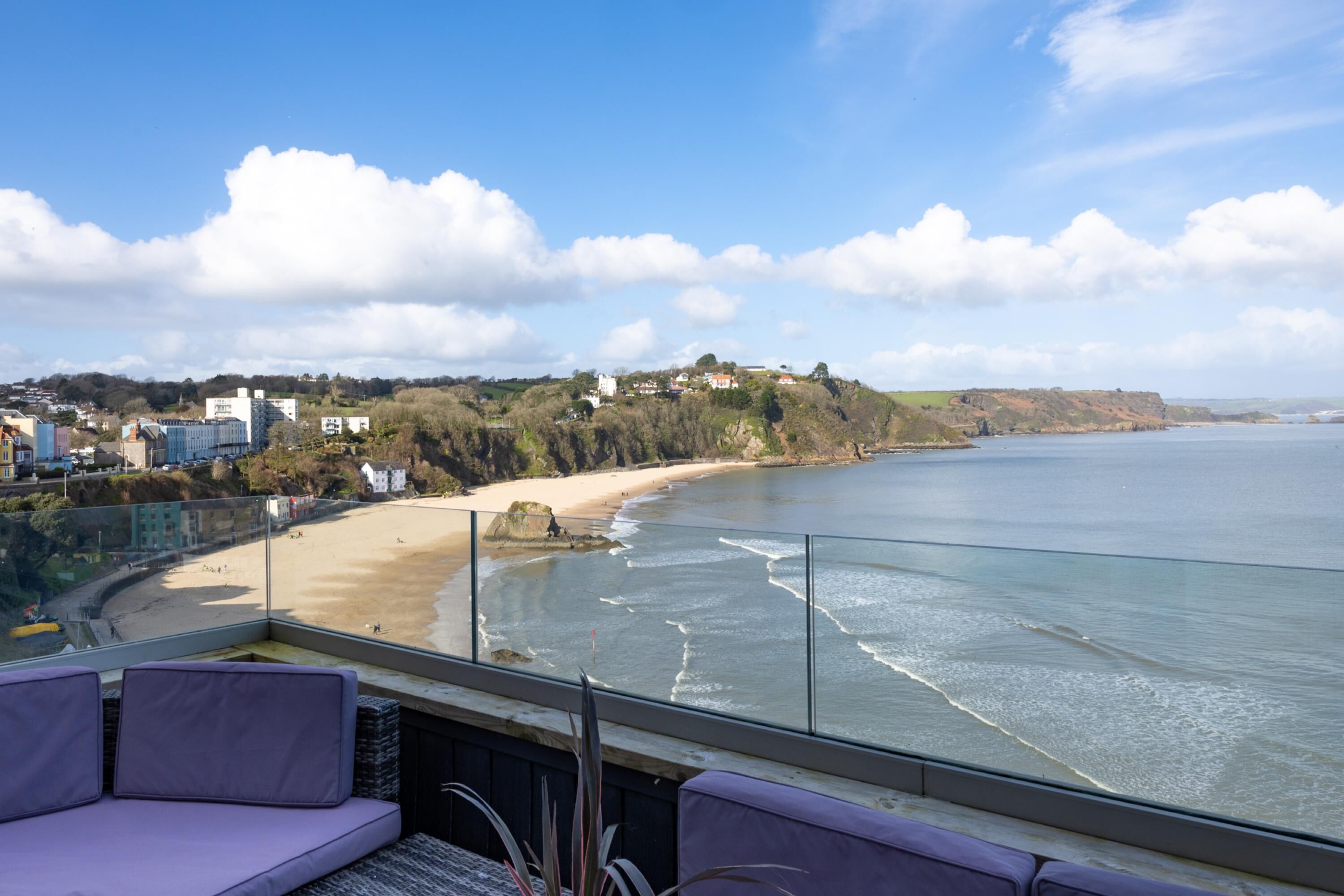 A balcony with a view of a beach and ocean.