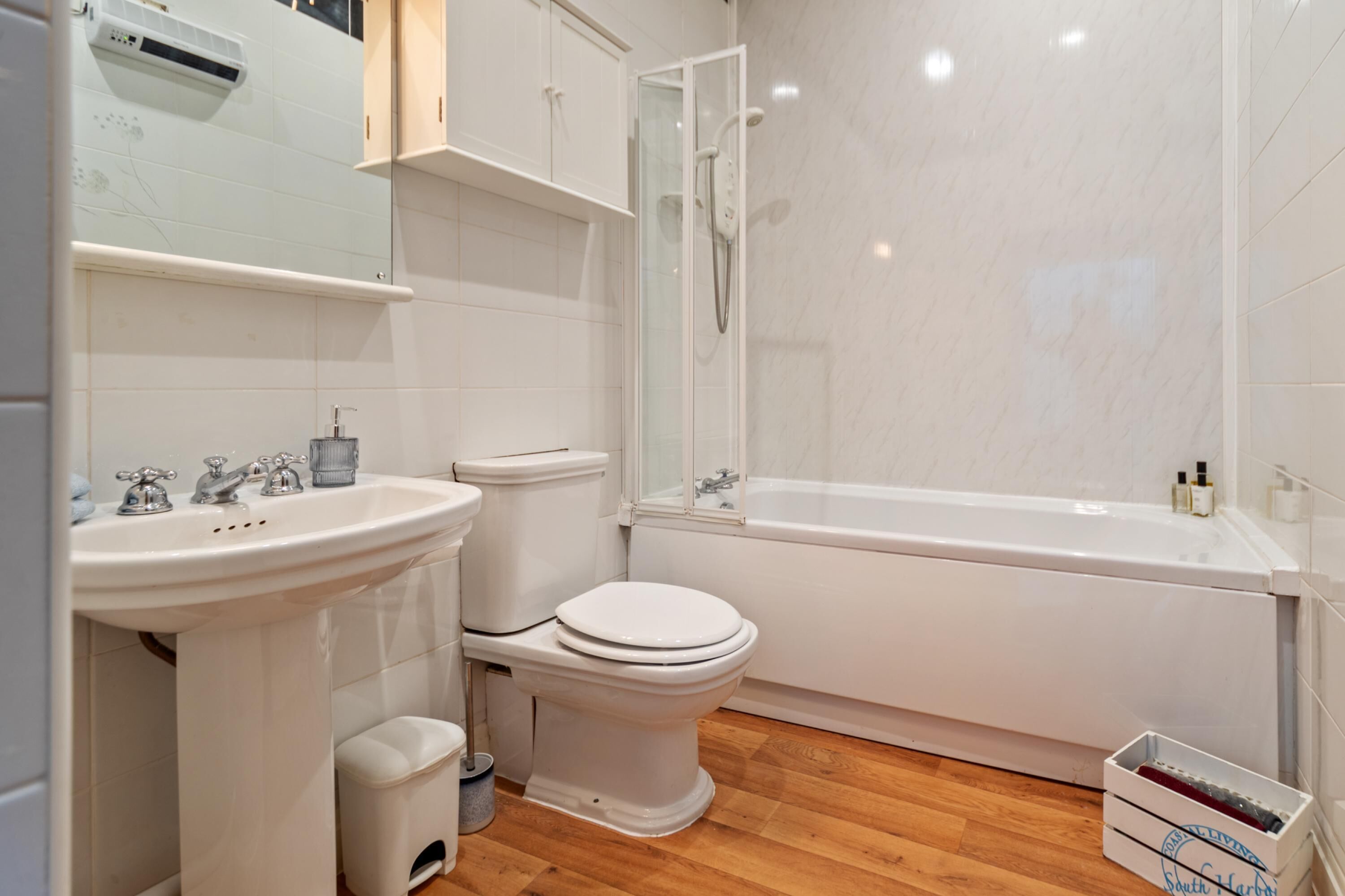 A modern bathroom with a white sink, toilet, and bathtub.