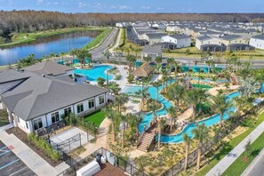 A residential area with a swimming pool, houses, and a road. - 9BR/5BA Game/Pool/Theater/Lakeview/Free waterpark Villa close to Disney (Kissimmee)