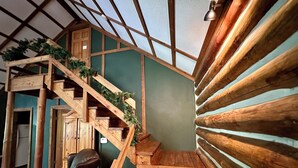 A wooden staircase with a green wall and a wooden bench.