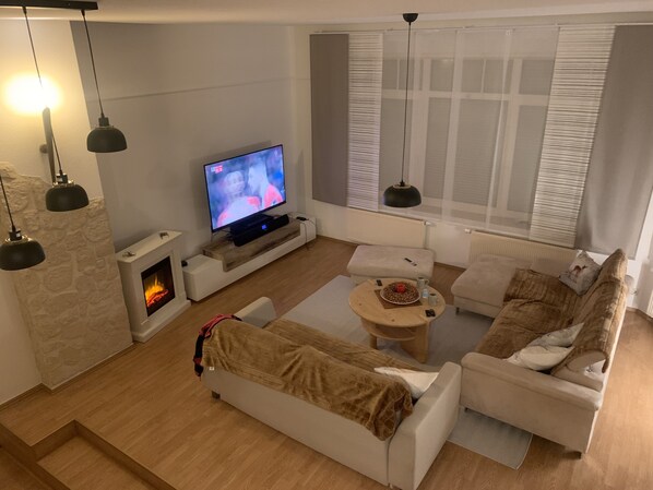 Smart TV, caminetto, libri, impianto stereo