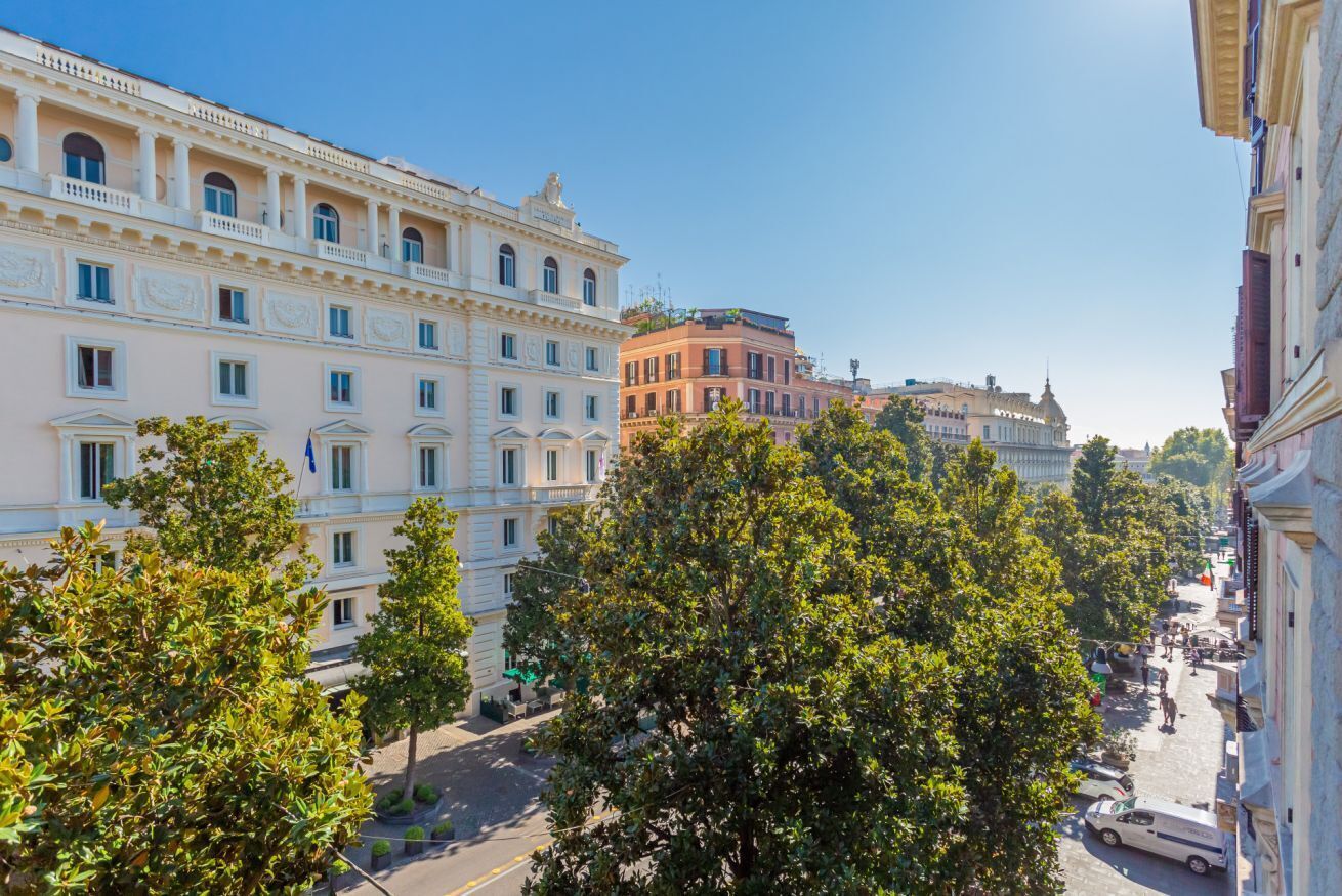 A street view with buildings, trees, and a clear sky.