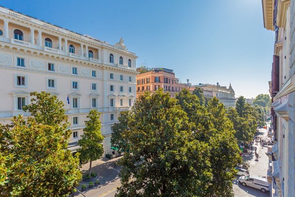 A street view with buildings, trees, and a clear sky.