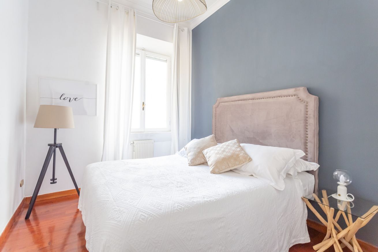 Ein Schlafzimmer mit einem Bett, einer Lampe und einem Nachttisch.