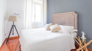 A bedroom with a bed, a lamp, and a bedside table. - Daplace - Alma Apartment (Roma)