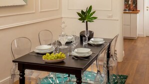 A dining table set with plates, glasses, and a bowl of fruit. - Daplace - Flaminia Apartment (Roma)